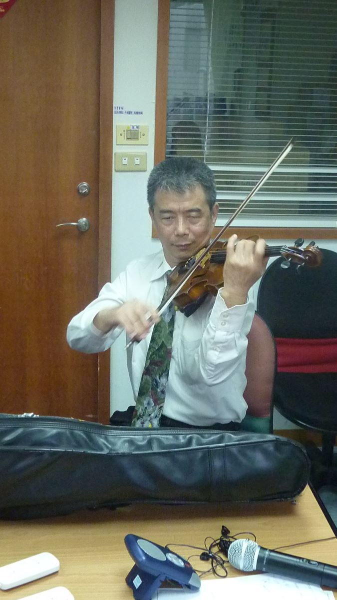 有藝術氣息的敦邦老師正專注地彈奏著小提琴